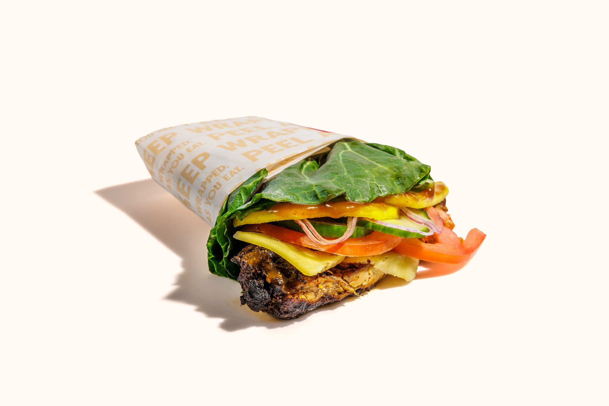 oven-roasted jerk chicken, peach mango salsa, no added sugar bbq, pepper jack cheese, tomatoes, cucumbers, fresh mango slices, onions, wrapped in swiss chard.