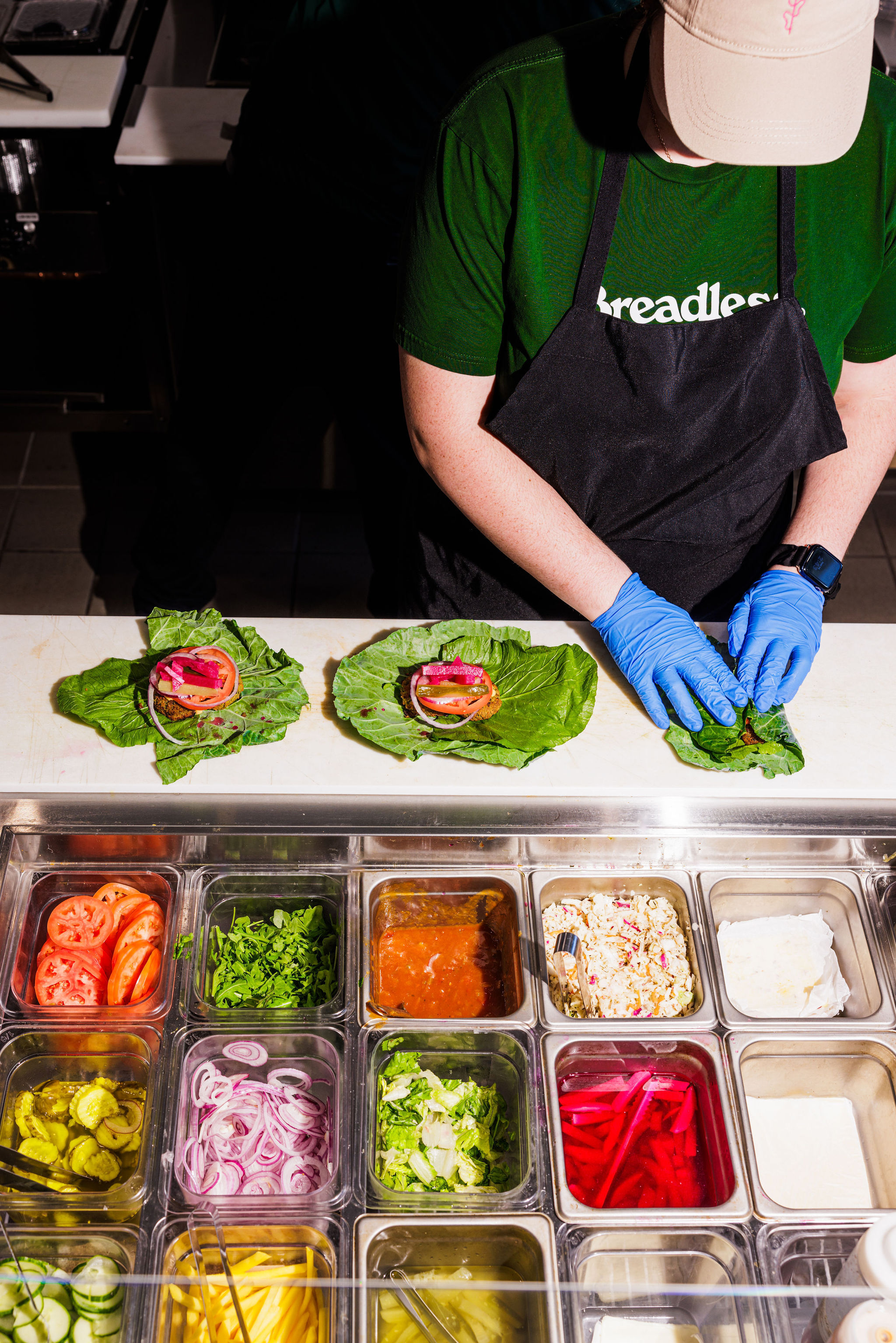 Behind the scenes at Breadless: fresh lettuce wraps being prepared with premium ingredients in a clean, modern kitchen.