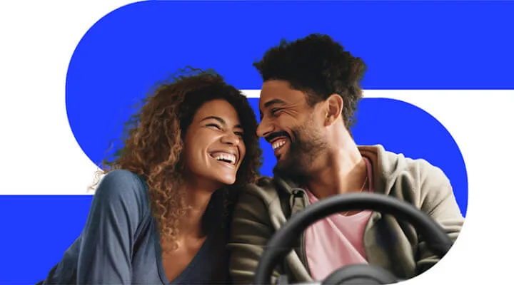 Casal sorrindo dentro de um carro sobre o fundo azul da NaPista, imagem principal da busca de veículos