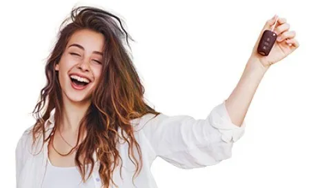 Jovem sorrindo e segurando a chave do seu primeiro carro, comemorando a conquista