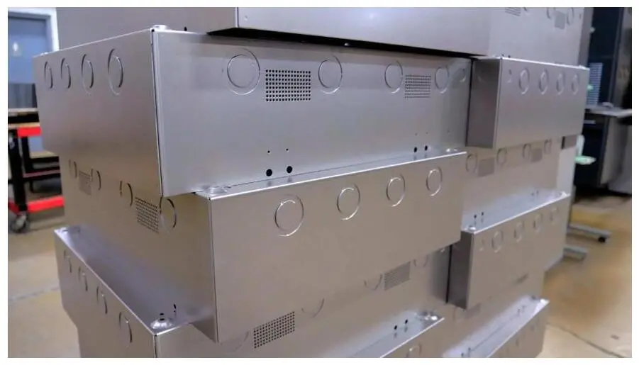 Stacked precision sheet-metal enclosures with ventilation cutouts.