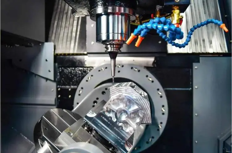 A five-axis CNC head machining a round metal workpiece.