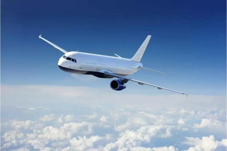 A commercial airliner in flight against a blue sky.