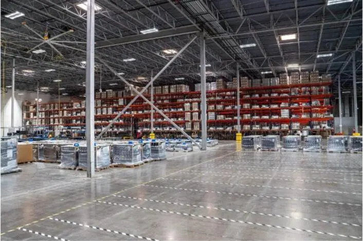 Interior of a large warehouse with tall pallet racking and palletized inventory.