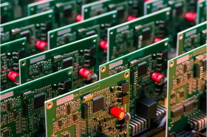 Rows of green printed circuit boards on a production line.