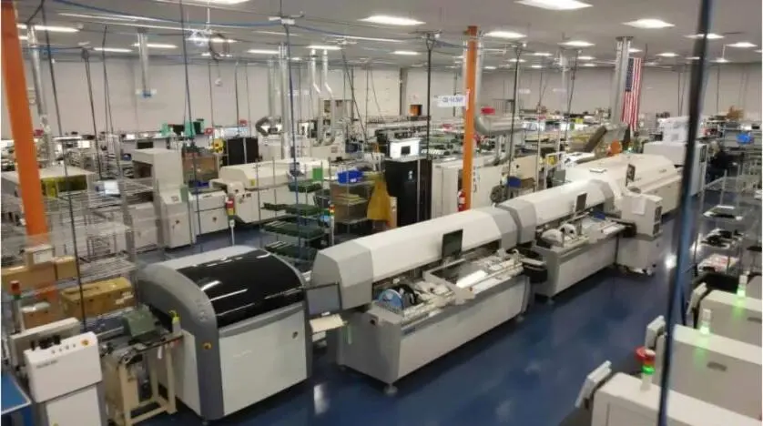 Wide interior view of a modern electronics manufacturing shop floor with assembly lines.