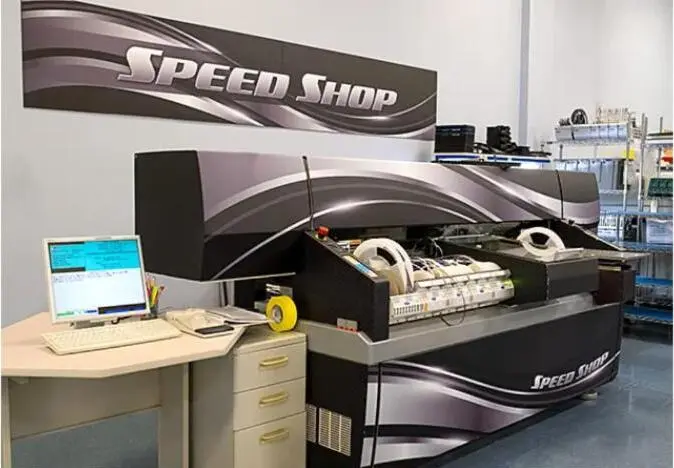 An industrial assembly machine branded "Speed Shop" on a prototyping line.