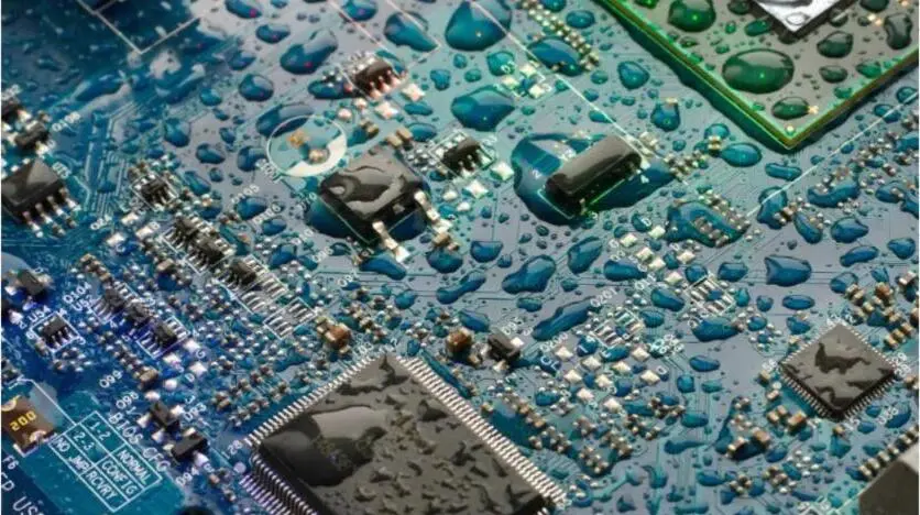 A circuit board beaded with water droplets, protected by a conformal coating.