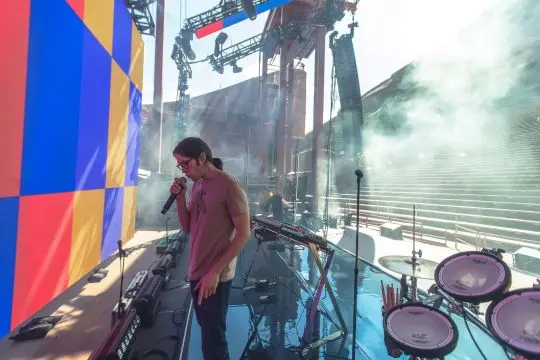 A colorful, high-energy live music set with stage lighting and instruments.