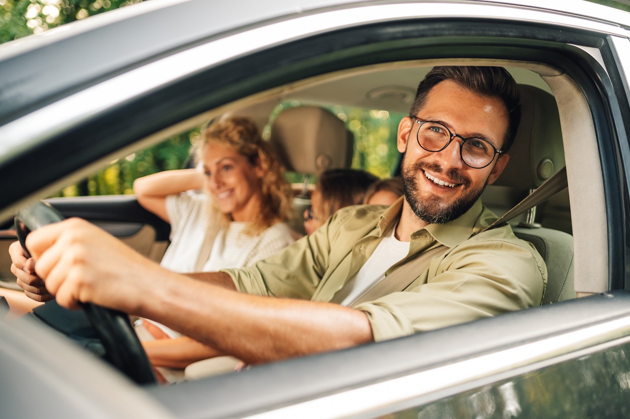 Família sorrindo dentro de um carro.