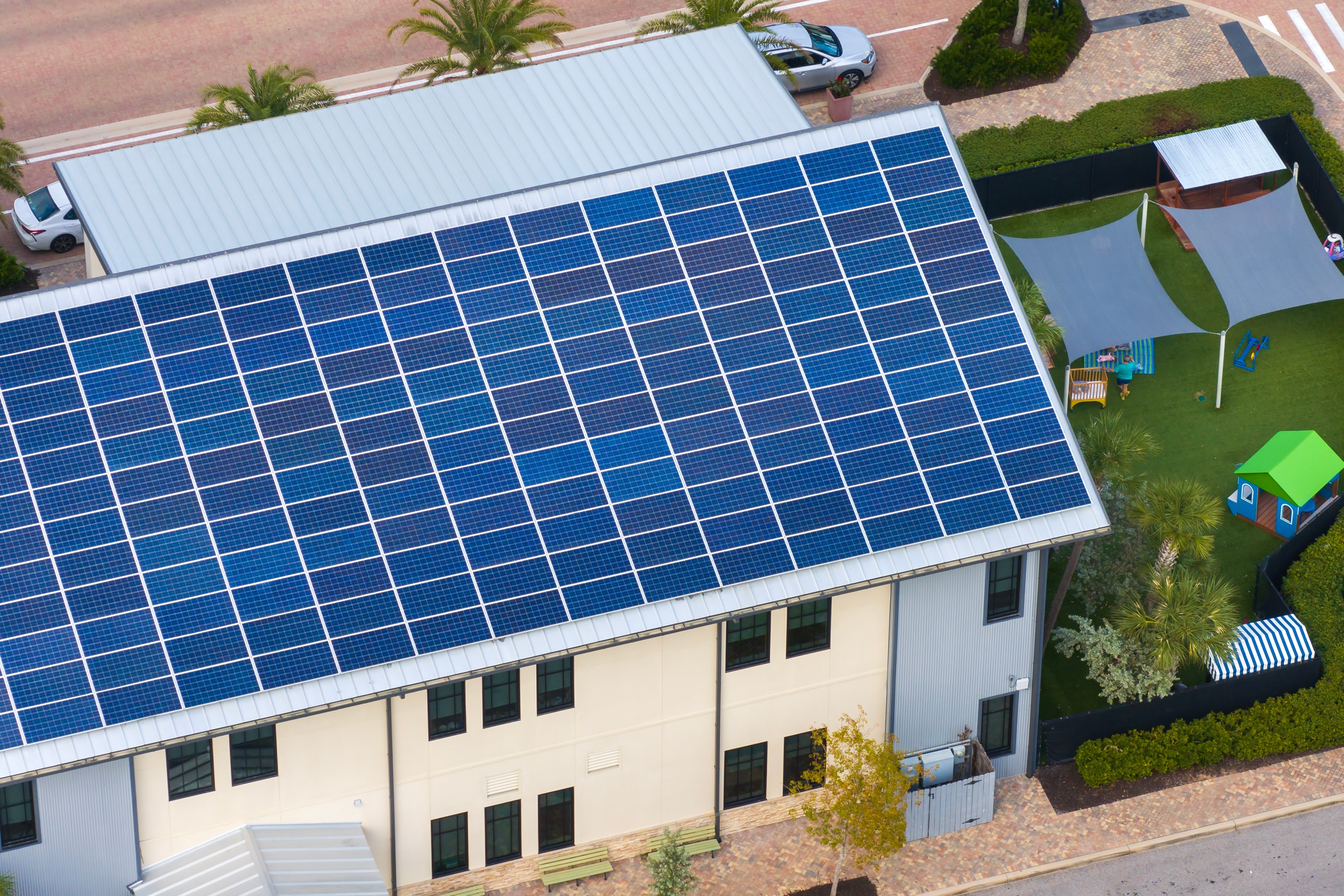 Vista aérea de um telhado totalmente coberto por painéis solares fotovoltaicos.