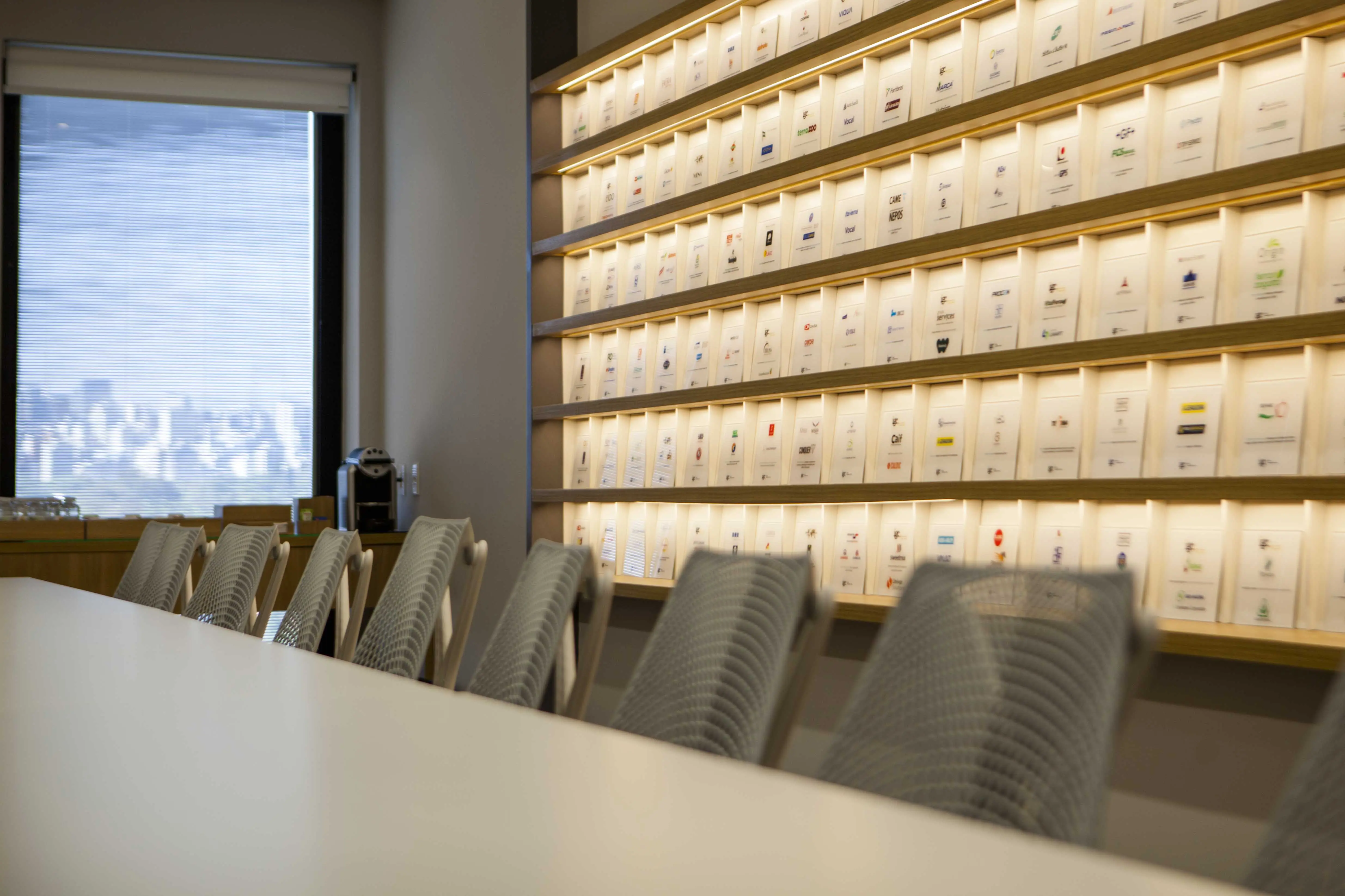 Sala de reuniões da igc partners com estante iluminada exibindo transações concluídas ao fundo