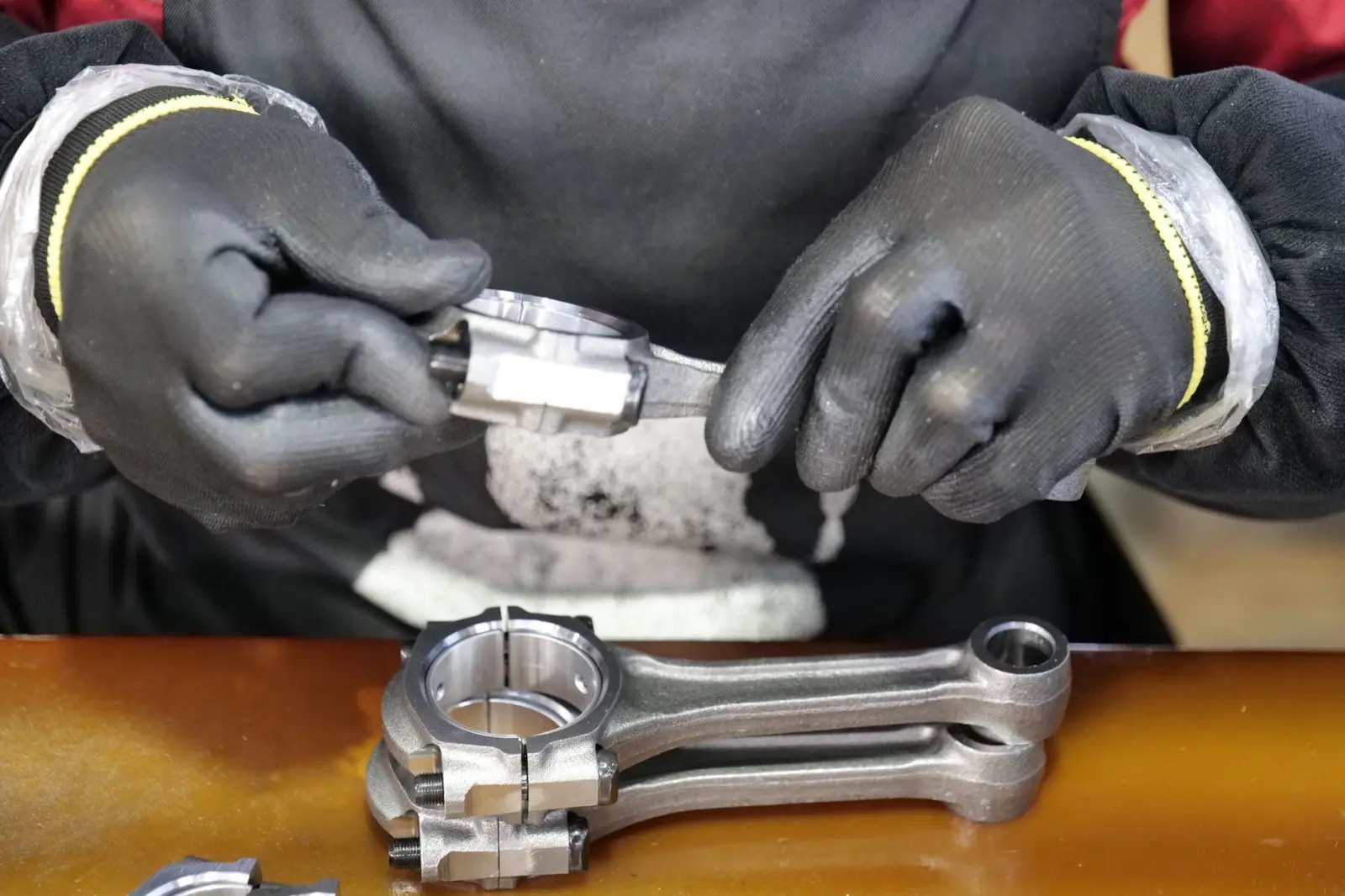 Hands using a caliper to measure a precision-machined metal component during inspection