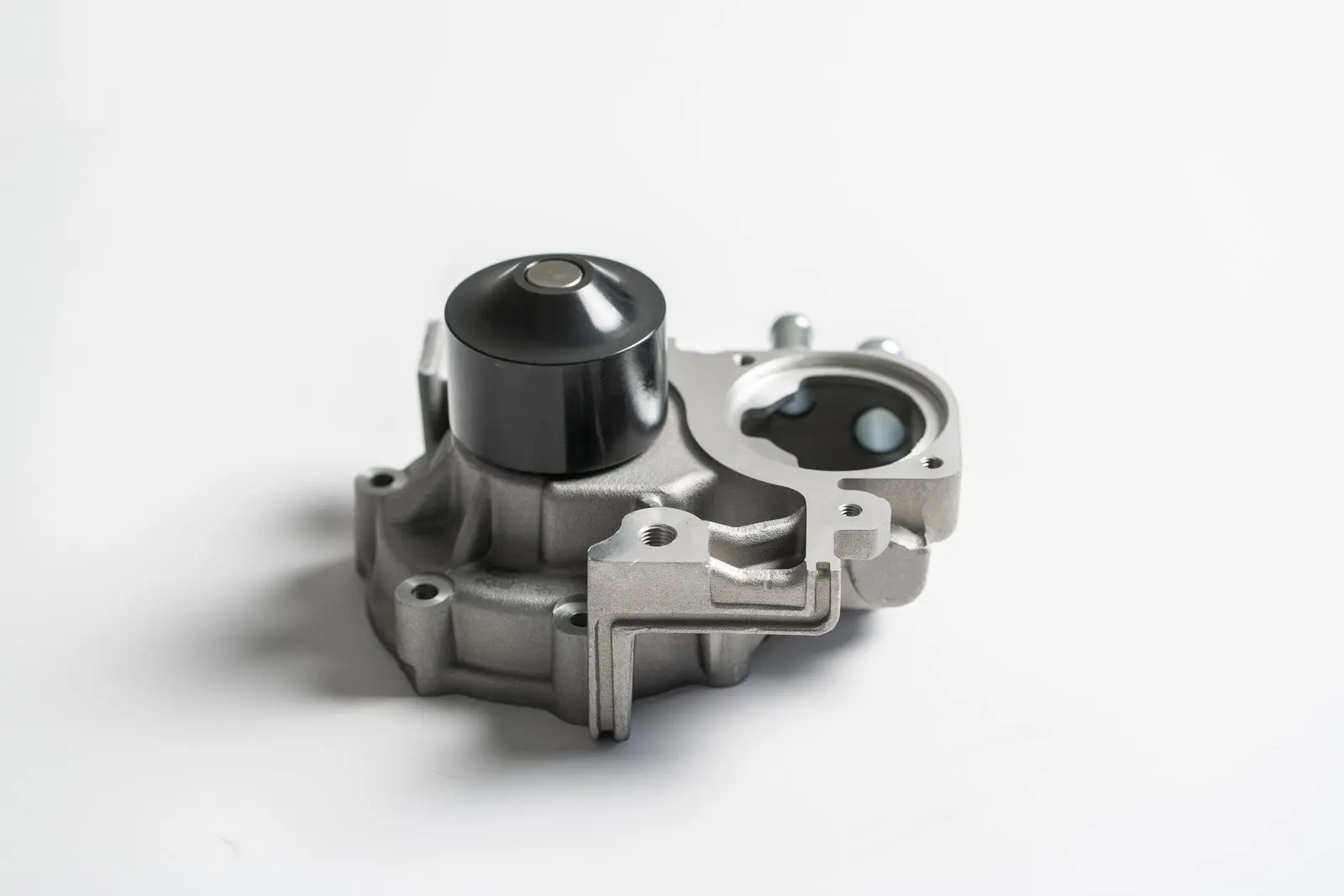 Die-cast metal water pump housing photographed on a white background