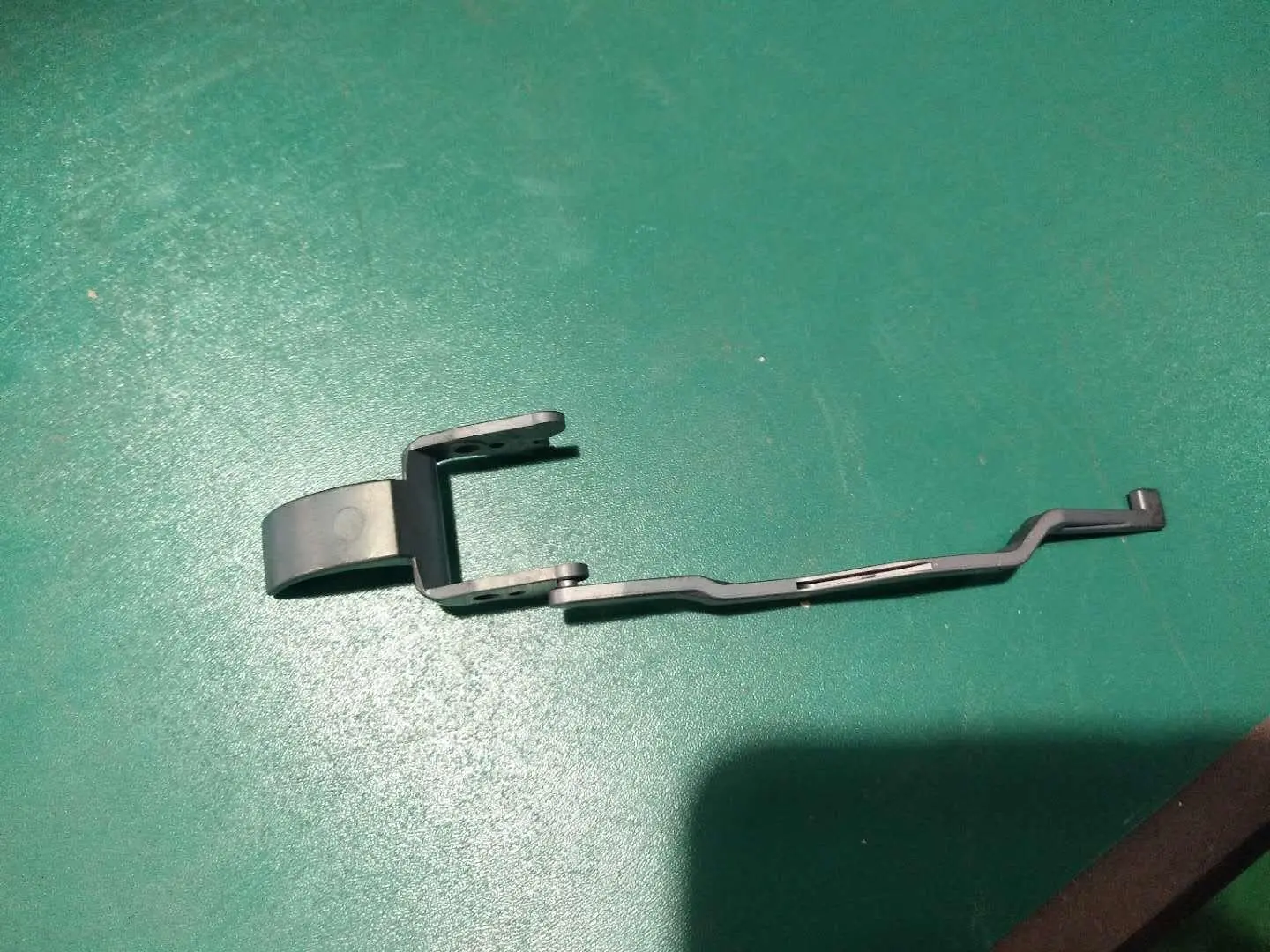 Small metal injection molded clip component on a green surface