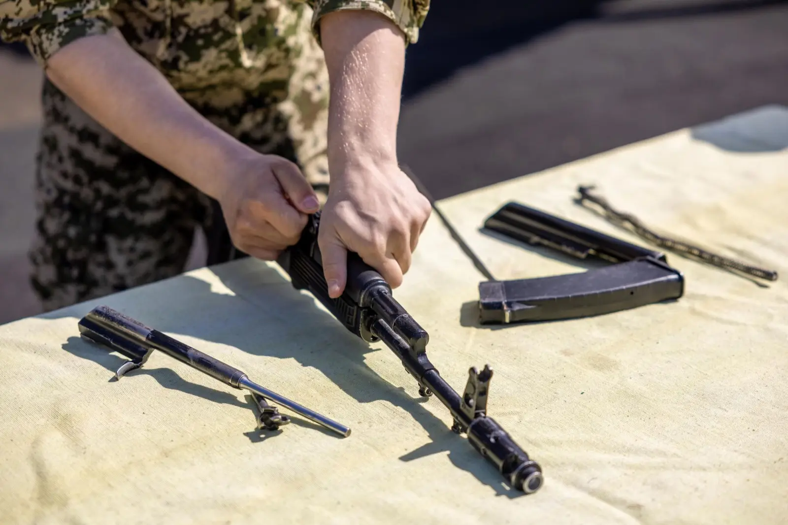 Hands assembling firearm components on a workbench