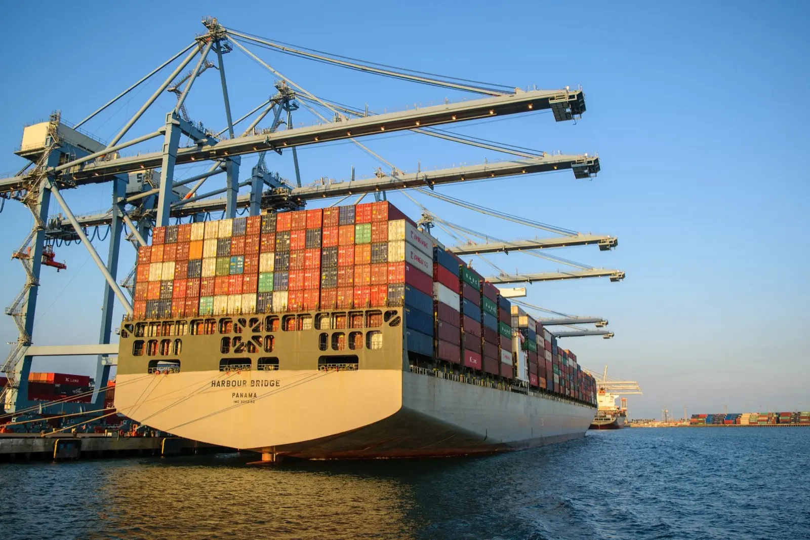Container ship loaded with cargo at port, representing managed overseas production and global supply chain