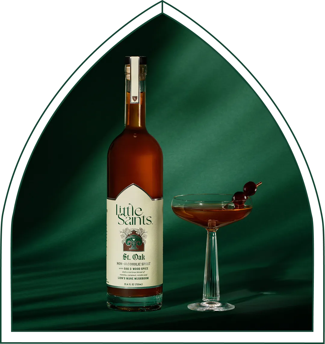 The Little Saints St. Oak non-alcoholic whiskey bottle beside a coupe cocktail.