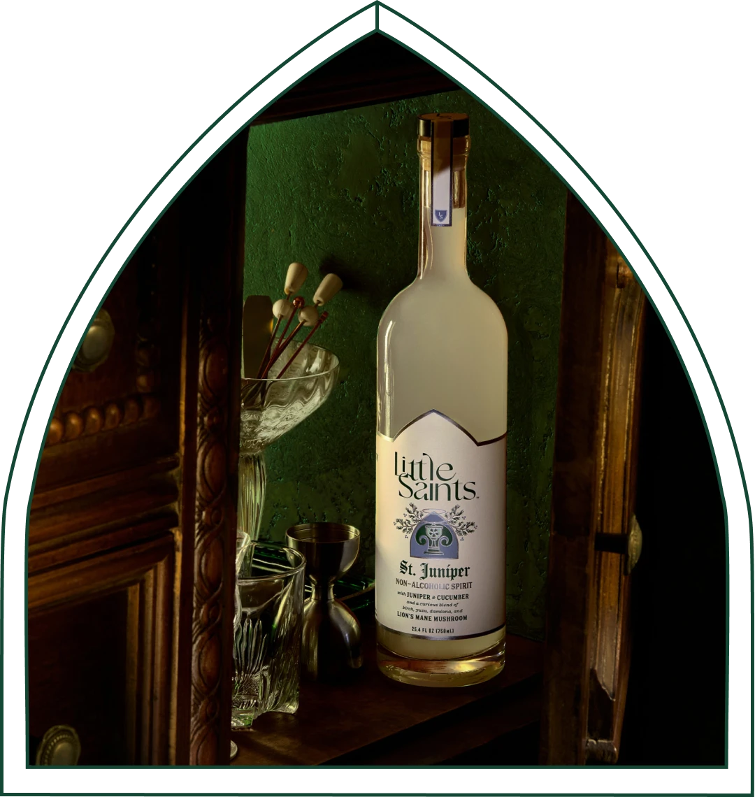 A Little Saints St. Juniper bottle styled in a moody, elegant bar setting.