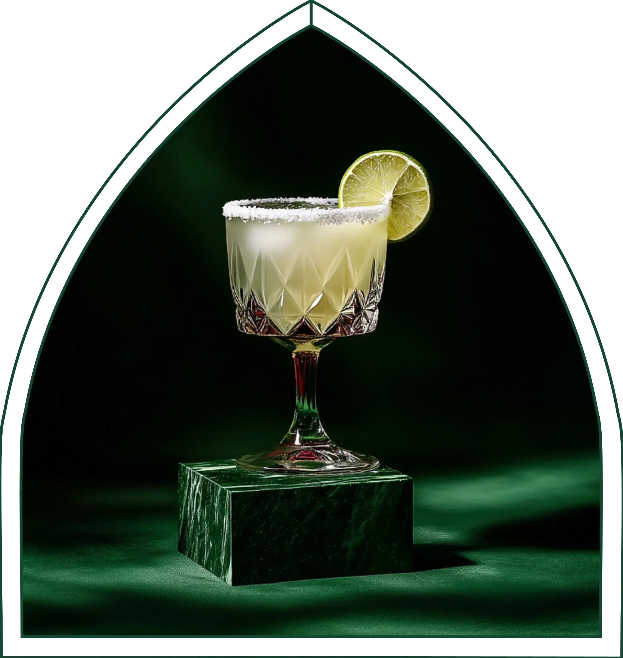 A non-alcoholic margarita in a coupe with a lime wheel and salt rim, on green marble.